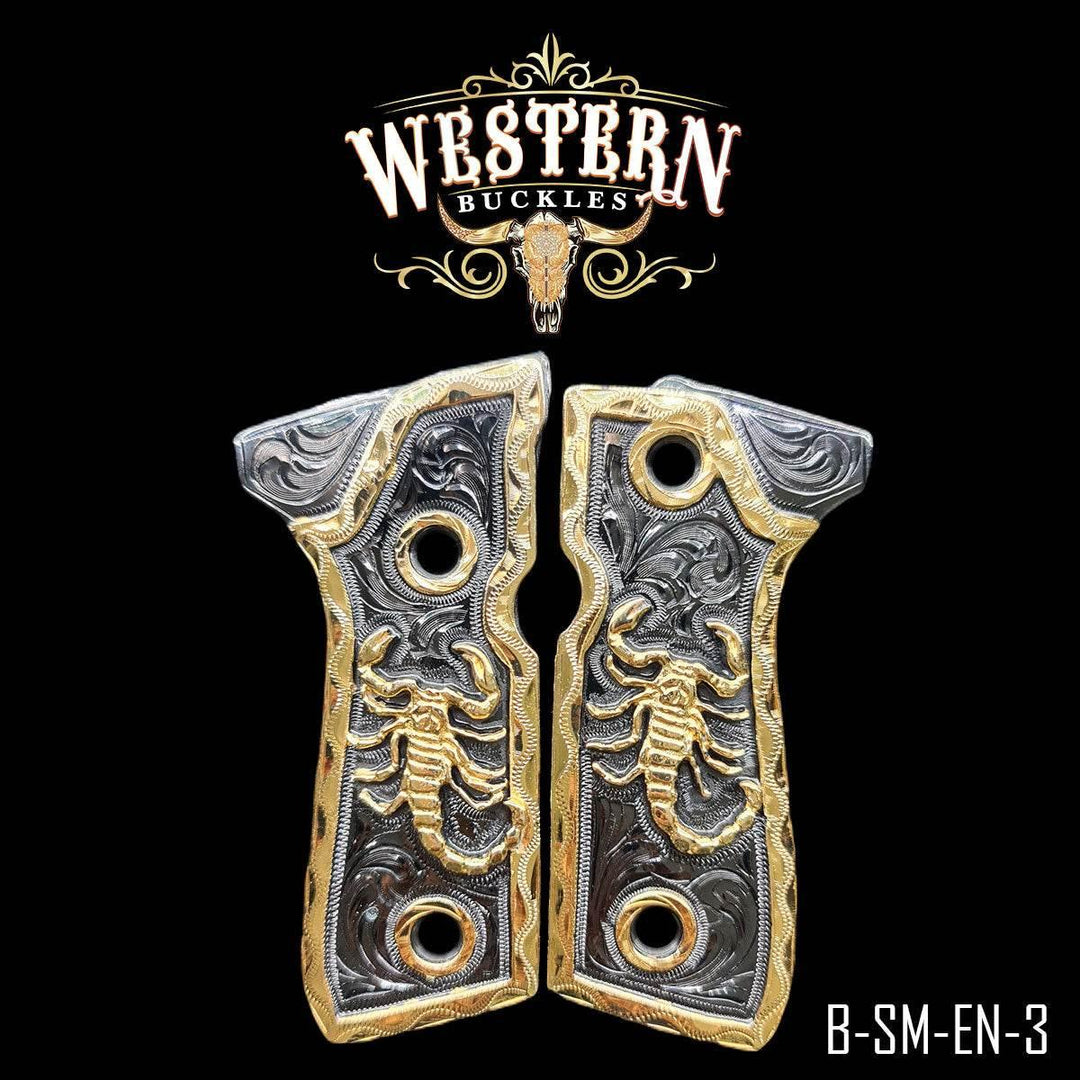 Custom Colt 1911 pistol grips with gold scorpion design, engraved metal, western style.