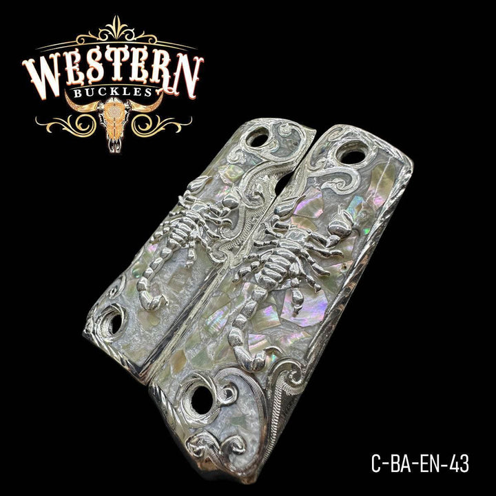 Custom 1911 pistol grips with silver scorpion design and abalone inlay on black background