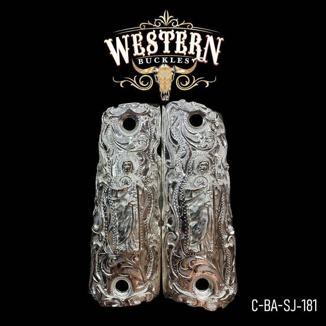 Detailed silver 1911 pistol grips with engraved saint design and western floral patterns.