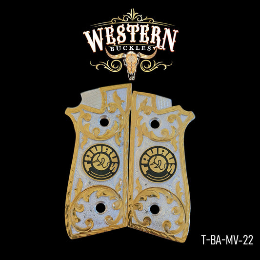 Gold and silver Taurus pistol grips with engraved scrollwork design on black background